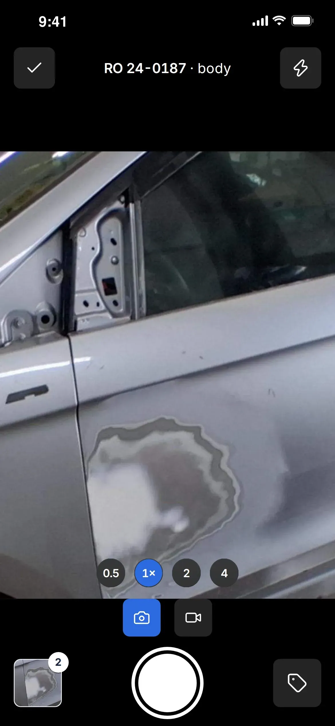 ShopCam phone app camera: repair order 24-0187 filing into Body repairs, a car panel in the viewfinder, zoom stops, photo and video modes, the shutter, the last photo with 2 waiting to send, and the Category button